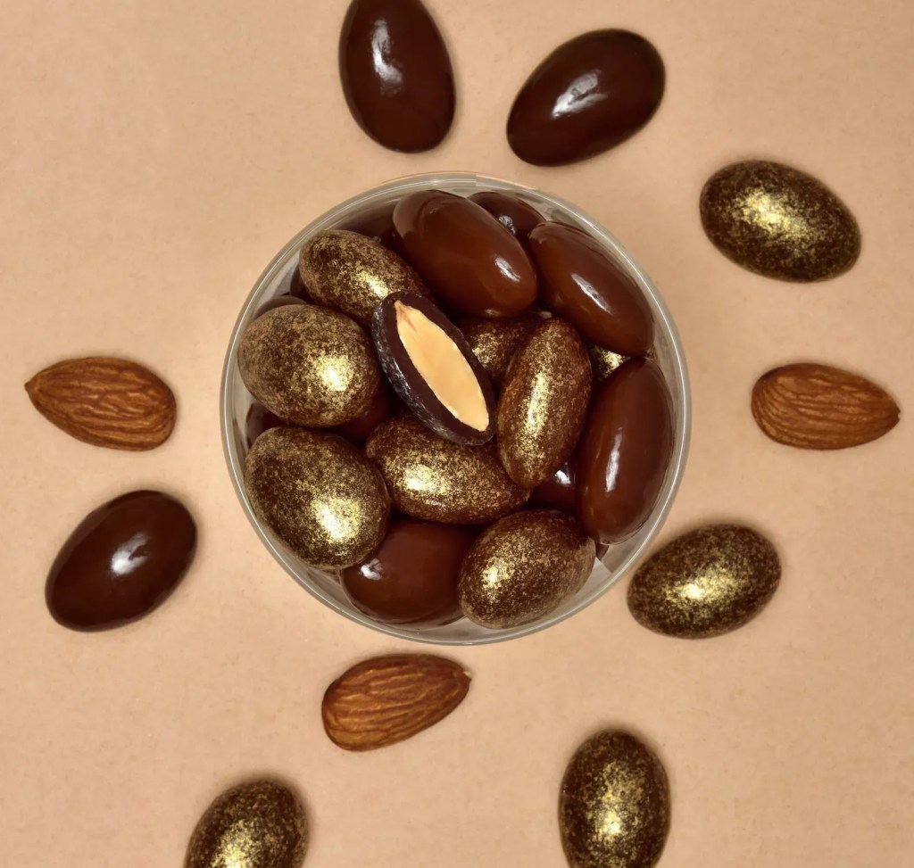 Chocolate-coated almonds with pearly gold decorative finish